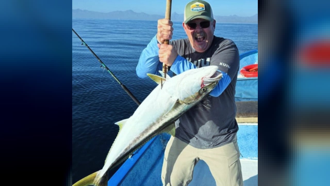 Pescador sonriente con un jurel recién capturado a bordo de la panga Loreto Star, Mar de Cortés